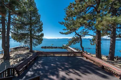 a walkway to the beach with trees and water at Red Wolf Lakeside Lodge in Tahoe Vista