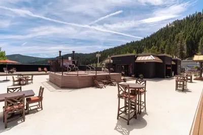 a patio with tables and chairs and a building at Red Wolf Lodge at Olympic Valley in Olympic Valley