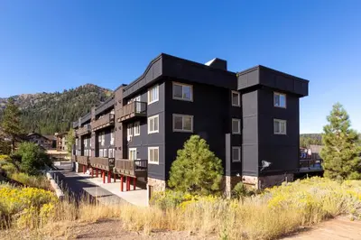 a black building with benches in front of it at Red Wolf Lodge at Olympic Valley in Olympic Valley