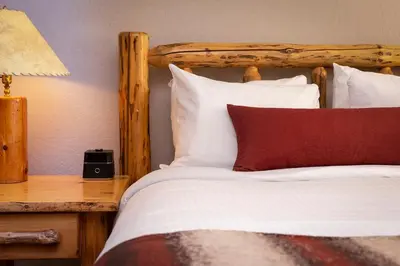 a bed with a wooden headboard and a red pillow at Red Wolf Lodge at Olympic Valley in Olympic Valley