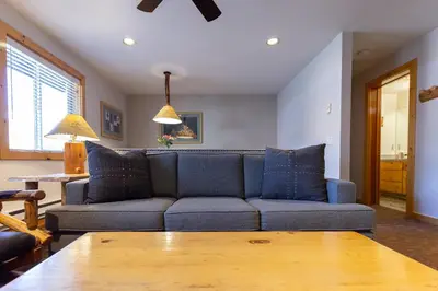 a living room with a blue couch and a table at Red Wolf Lodge at Olympic Valley in Olympic Valley
