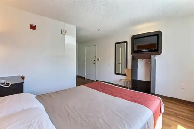 a hotel room with a bed and a flat screen tv at Motel 6-Gilroy, CA in Gilroy