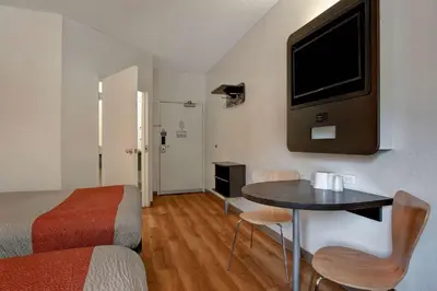 a hotel room with a bed and a table with a tv at Motel 6-Gilroy, CA in Gilroy