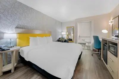 a hotel room with a large bed and a bathroom at Hillstone Inn Tulare, an Ascend Collection Hotel in Tulare