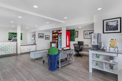 a lobby with a waiting room with a desk and a computer at Hillstone Inn Tulare, an Ascend Collection Hotel in Tulare
