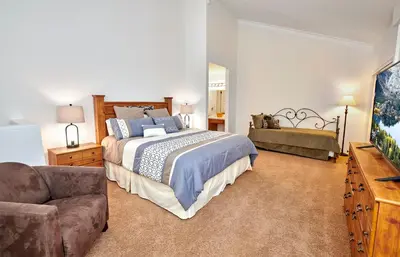 a bedroom with a large bed and a couch at Austria Hof Lodge in Mammoth Lakes