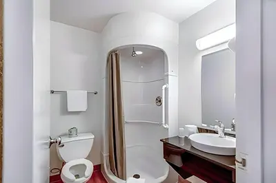 a white bathroom with a toilet and a sink at Super 8 by Wyndham Tracy in Tracy
