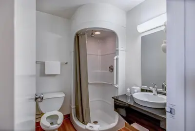 a white bathroom with a toilet and a sink at Super 8 by Wyndham Tracy in Tracy