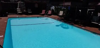 a large blue swimming pool with chairs around it at Gondola Lodge & Tahoe Beach Club in South Lake Tahoe
