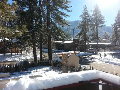 a snow covered parking lot with trees and a building at Gondola Lodge & Tahoe Beach Club in South Lake Tahoe
