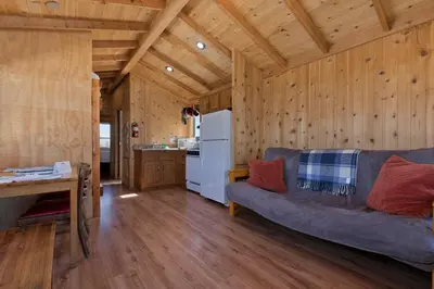 a living room with a couch and a kitchen at Sierra Meadows Ranch in Mammoth Lakes