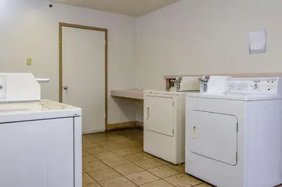 a laundry room with white appliances and a counter at Studio 6-Fresno, CA - Extended Stay in Pinedale
