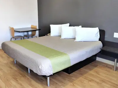 a large bed in a room with a table at Studio 6-Fresno, CA - Extended Stay in Pinedale