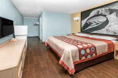 a hotel room with a bed and a flat screen tv at Super 8 by Wyndham Bishop in Bishop