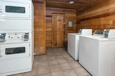 a kitchen with white appliances and a washer and dryer at Super 8 by Wyndham Bishop in Bishop