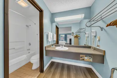 a bathroom with a sink and a toilet and a mirror at Days Inn by Wyndham Carson City in Carson City