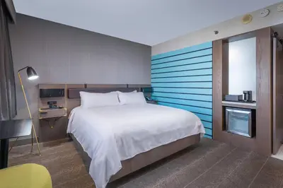 a bedroom with a large bed with a blue stripe at Renaissance Reno Downtown Hotel & Spa in Reno