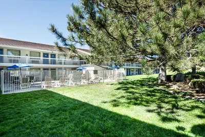a yard with chairs and umbrellas in front of a building at Motel 6-Sparks, NV - Airport - Sparks in Reno