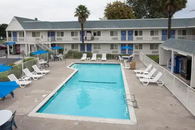 a swimming pool with lounge chairs and a hotel at Motel 6-Sacramento, CA - Central in Sacramento