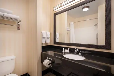 a bathroom with a sink and a toilet and a mirror at Fairfield Inn & Suites by Marriott Visalia Tulare in Tulare