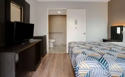 a hotel room with a bed and a bathroom at Motel 6-Rancho Cordova, CA - Rancho Cordova East in Rancho Cordova