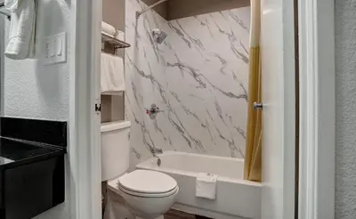 a bathroom with a toilet and a tub and a sink at Motel 6-Rancho Cordova, CA - Rancho Cordova East in Rancho Cordova
