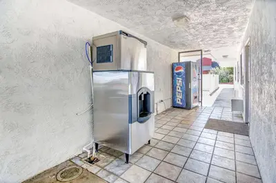 a kitchen with a stainless steel refrigerator in a room at Motel 6-Stockton, CA - Charter Way West in Stockton