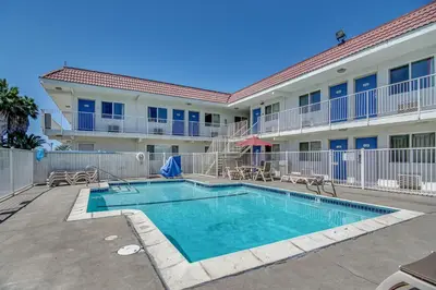 a swimming pool in front of a apartment building at Motel 6-Stockton, CA - Charter Way West in Stockton