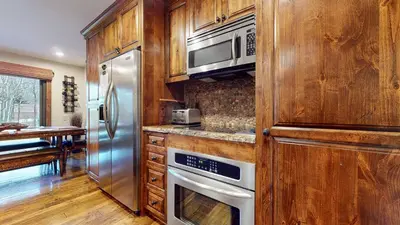 a kitchen with wooden cabinets and a microwave and a refrigerator at Snowcreek 269 Condo in Mammoth Lakes