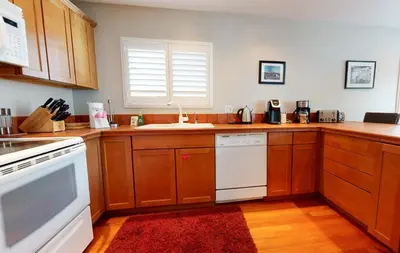 a kitchen with wooden cabinets and a white dishwasher at Sierra Manors 8 Townhouse in Mammoth Lakes