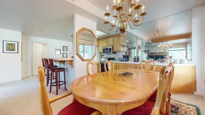a dining room and kitchen with a wooden table and chairs at Silver Bear 18 Condo in Mammoth Lakes