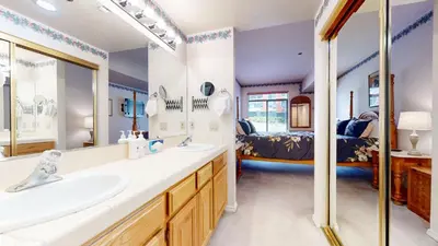 a bathroom with two sinks and a bed at Silver Bear 18 Condo in Mammoth Lakes