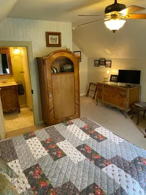 a bedroom with a quilt on a bed and a desk at B Street House Inn in Virginia City