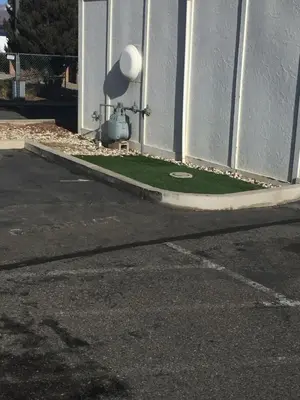 a corner of a building with a grassy area next to a street at Super 8 by Wyndham Carson City Lake Tahoe in Carson City