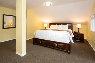 a bedroom with a large bed and a mirror at Edelweiss Lodge in Mammoth Lakes