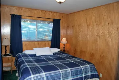 a bedroom with a blue and white bed with a window at Edelweiss Lodge in Mammoth Lakes