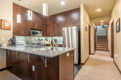 a kitchen with wooden cabinets and a stainless steel refrigerator at Solstice 6 in Mammoth Lakes