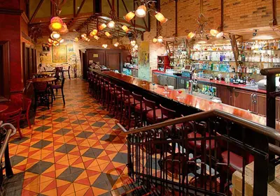 a restaurant with a bar with chairs and tables at Eldorado Reno, A Caesars Destination in Reno