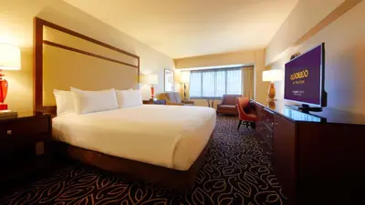 a hotel room with a bed and a flat screen tv at Eldorado Reno, A Caesars Destination in Reno