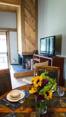 a dining room with a table with a vase of flowers at Aspen Grove 3090 in Truckee