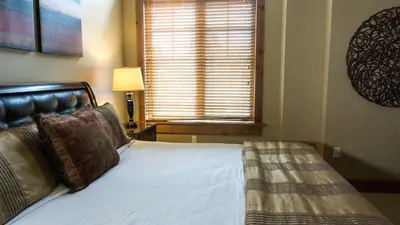 a bedroom with a bed and a window with a window blind at Catamount 407C in Truckee