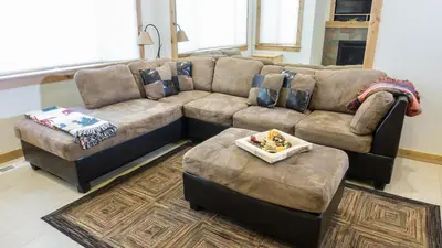 a living room with a couch and ottoman at Ski Trails 4070 in Truckee