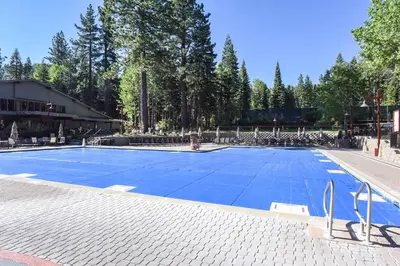 a large swimming pool in a park with trees at Ski Trails 4113 in Truckee