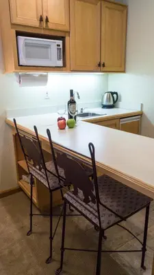 a kitchen with a counter with a microwave and two chairs at Northstar Village 237 in Truckee