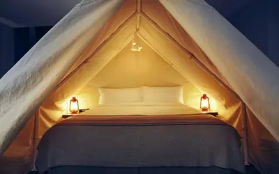a bed in a tent with two lights on it at Basecamp Tahoe South in South Lake Tahoe