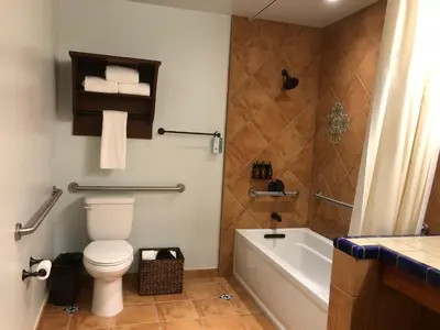 a bathroom with a toilet and a bath tub at Hotel Mission De Oro in Santa Nella Village