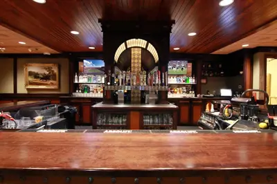 a bar with a large wooden counter top at Hotel Mission De Oro in Santa Nella Village