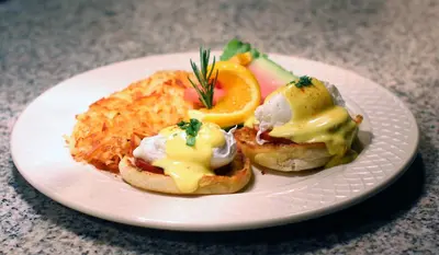 a white plate of food with eggs and toast at Hotel Mission De Oro in Santa Nella Village