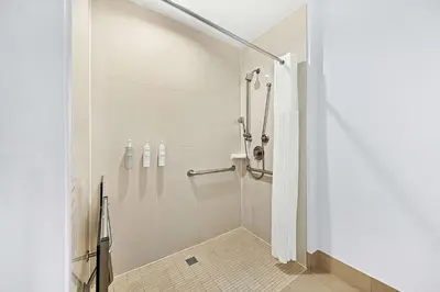 a white bathroom with a shower in a room at Hampton Inn Morgan Hill in Morgan Hill