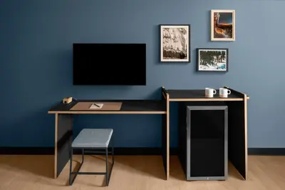a desk with a tv on a blue wall at evo Hotel Tahoe City in Tahoe City
